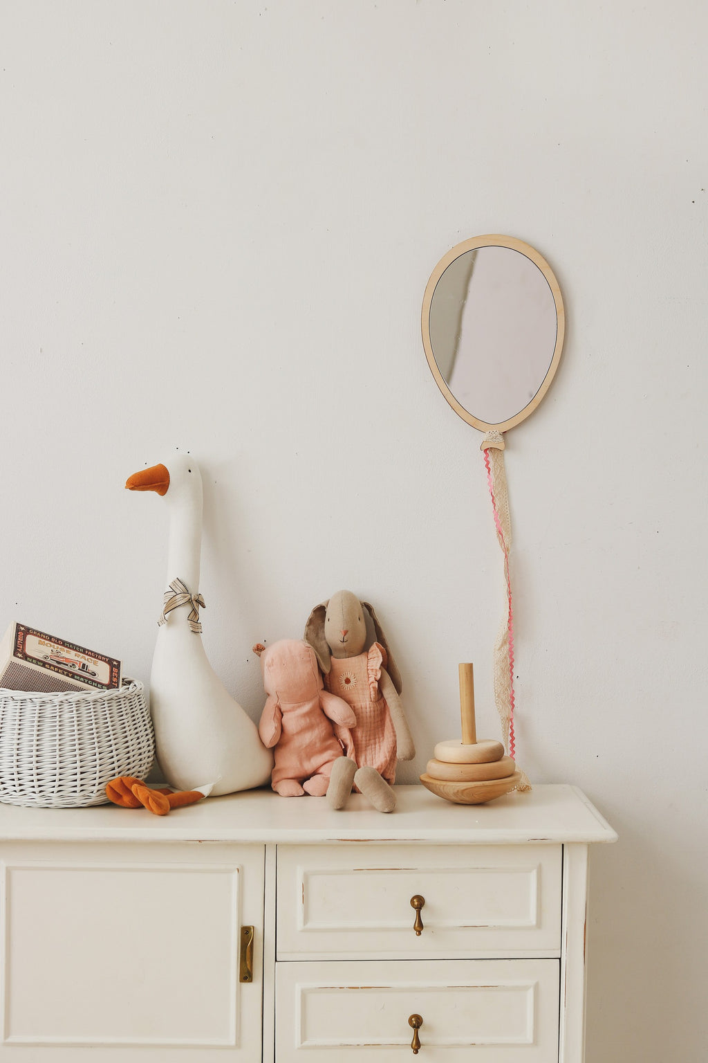 Soft handmade pale pink teddy-pattern blanket draped on a chair in a cozy baby room