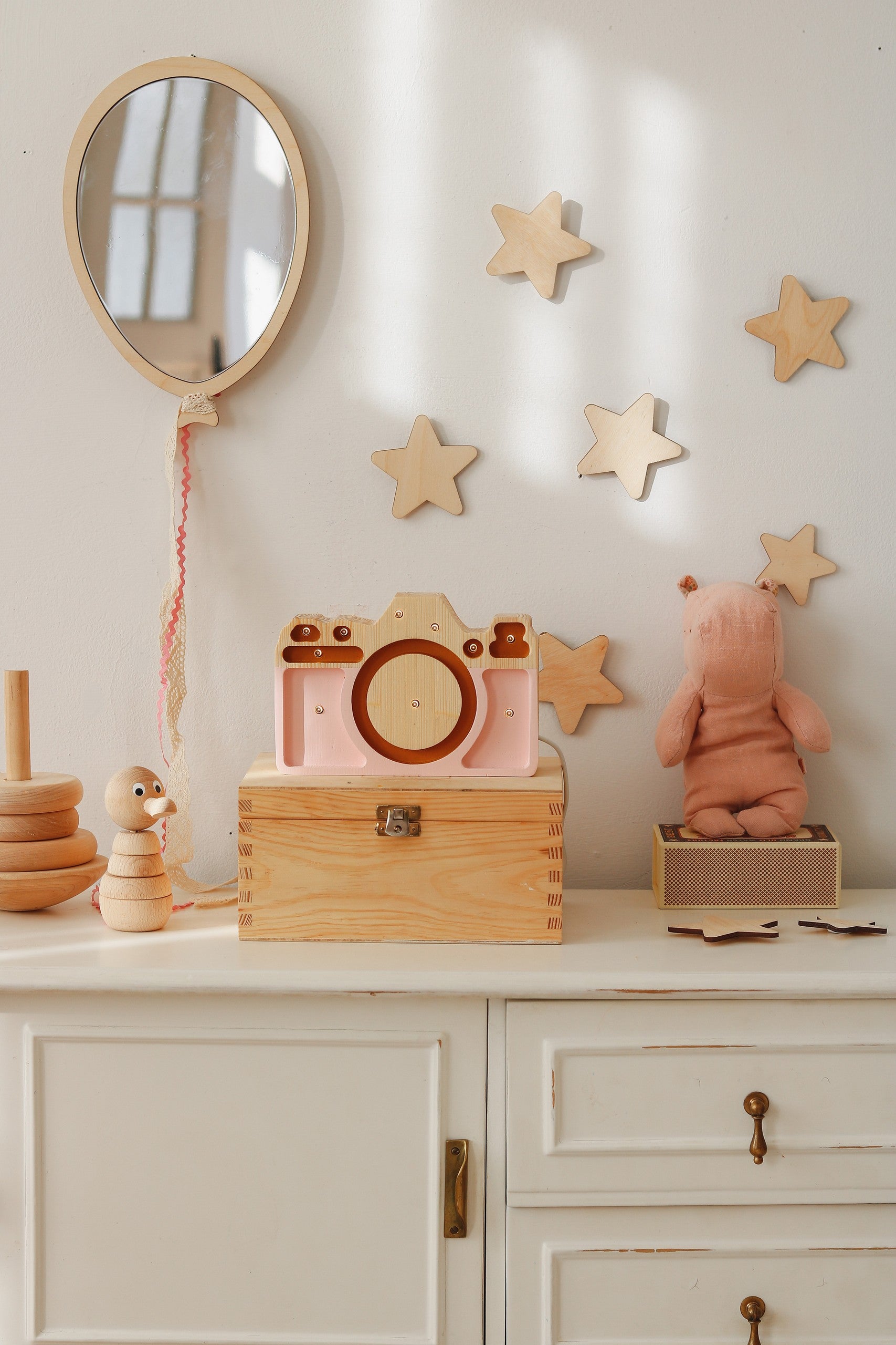 Soft handmade pale pink bear-patterned blanket draped on a chair in a cozy baby room
